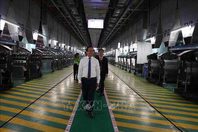 Phó Chủ tịch UBND tỉnh Tây Ninh Nguyễn Hồng Thanh (đứng đầu) tham quan Nhà máy sản xuất sợi tổng hợp và vải thành phẩm Unitex. Ảnh: Thanh Tân - TTXVN