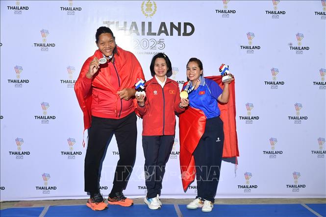 Trưởng đoàn Lê Thị Hoàng Yến (giữa) chia vui với hai vận động viên giành HCV và HCB môn Ném đĩa F57. Ảnh: TTXVN phát
