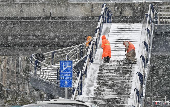 Công nhân dọn tuyết trên cầu đi bộ ở thành phố Hợp Phì, tỉnh An Huy, Trung Quốc, ngày 20/1/2026. Ảnh: THX/TTXVN