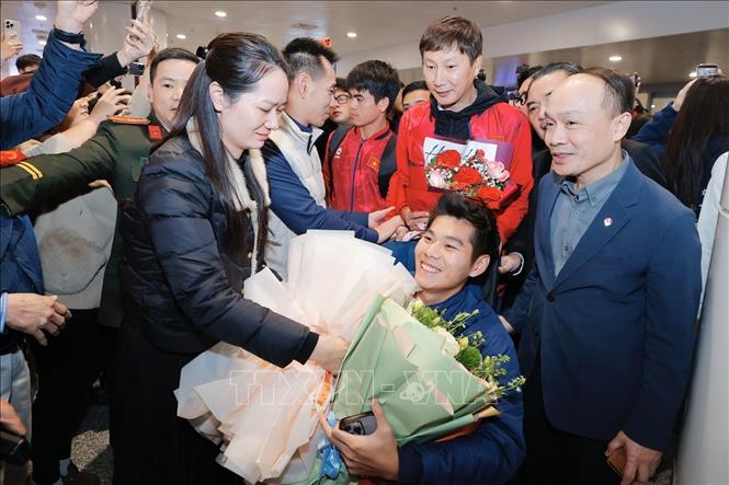 Người thân tặng hoa cầu thủ Hiểu Minh tại sân bay Nội Bài (Hà Nội). Ảnh: Minh Quyết - TTXVN