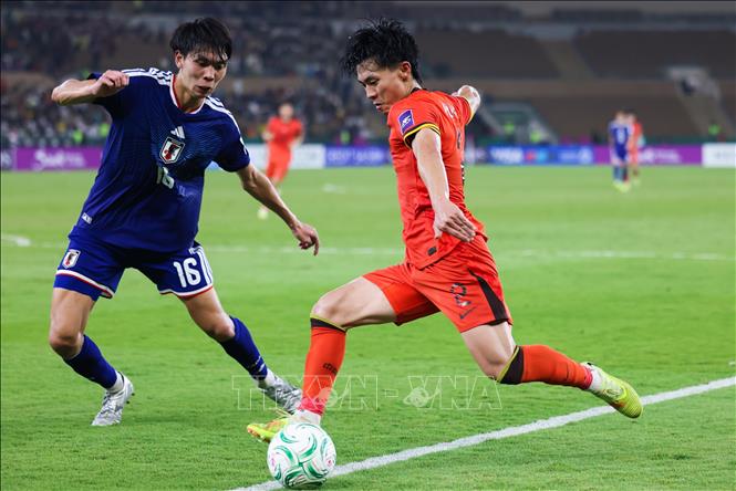 Pha tranh bóng giữa Hu Hetao (phải) của U23 Trung Quốc với Koizumi Kaito (giữa) của U23 Nhật Bản. Ảnh: THX/TTXVN
