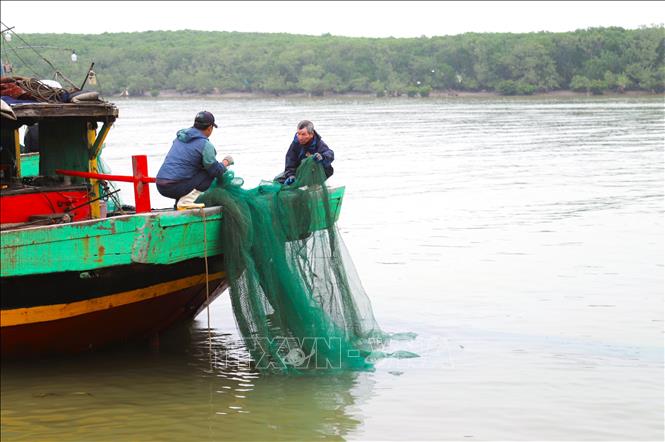 Ngư dân giặt giã, ngư lưới cụ để tiếp tục gối chuyến, vươn khơi bám biển. Ảnh: Xuân Tiến - TTXVN 