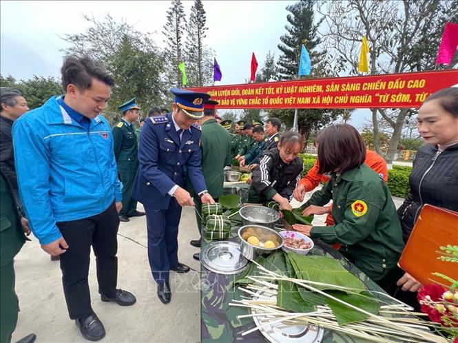 Các đại biểu theo dõi, động viên các đội tham gia hội thi gói bánh chưng xanh. Ảnh: TTXVN phát