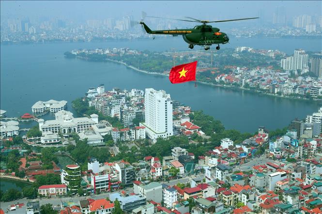 Trực thăng mang cờ tổ quốc bay trên Quảng trường Ba Đình. Ảnh: Trọng Đức-TTXVN