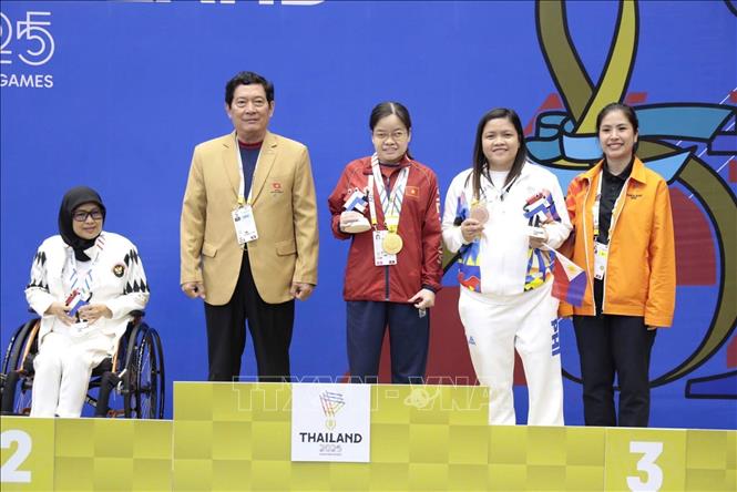 Ông Huỳnh Vĩnh Ái – Chủ tịch Hiệp hội Paralympic Việt Nam trao HCV  cho kỳ thủ Trần Thị Bích Thủy. Ảnh: TTXVN