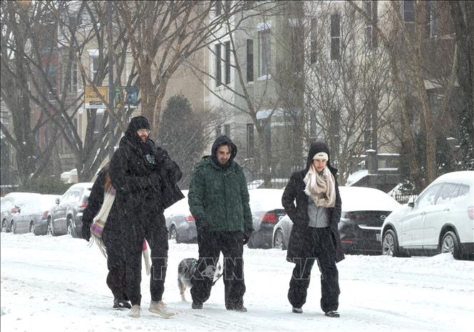 Người dân di chuyển khó khăn trong gió tuyết trên phố Calvert ở thủ đô Washington ngày 25/1/2026, khi bão mùa Đông khiến tuyết phủ dày và đường trơn trượt. Ảnh: Ngọc Quang, PV TTXVN tại Mỹ