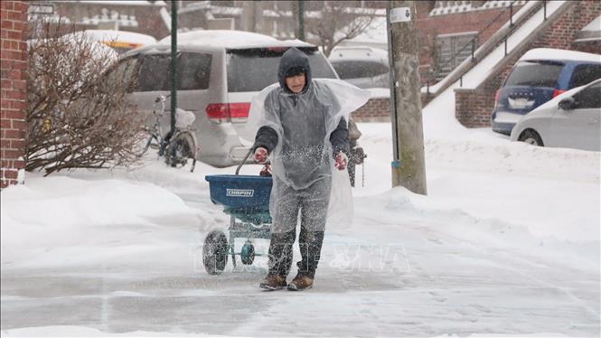 Người dân rải muối để chống trơn trượt. Ảnh: Thanh Tuấn - Phóng viên TTXVN tại Mỹ