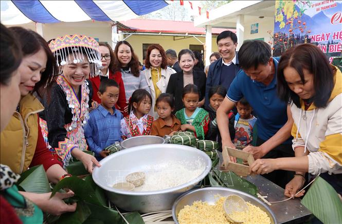 Thầy cô giáo tại điểm trường bản Nậm Ty 2 trong phần thi gói bánh chưng. Ảnh: Trung Kiên - TTXVN