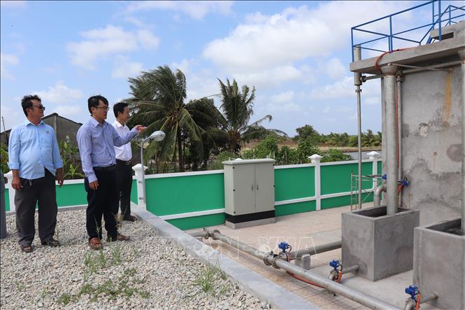 Lãnh đạo Trung tâm Nước sạch và Vệ sinh môi trường nông thôn Cần Thơ khảo sát Trạm cấp nước Lạc Hòa (phường Vĩnh Châu), điểm cấp nước miễn phí cho người dân. Ảnh: Thu Hiền - TTXVN