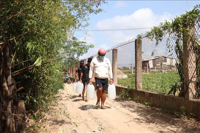 Người dân lấy nước miễn phí về sử dụng. Ảnh: Thu Hiền - TTXVN