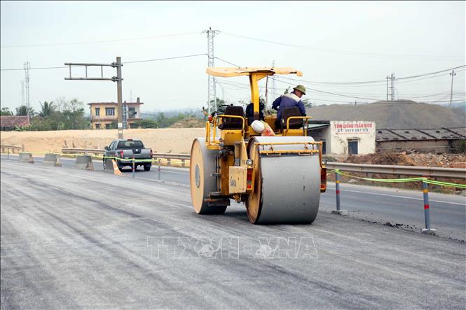 Đơn vị thị công đang hoàn thiện lu lèn đường dẫn hai bên đầu cầu Gianh. Ảnh: Tá Chuyên - TTXVN