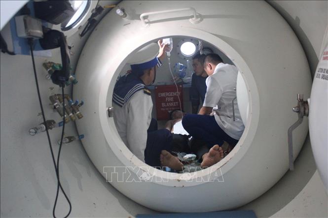 Các bác sĩ tiến hành cấp cứu cho ngư dân bị giảm áp. Ảnh: TTXVN phát