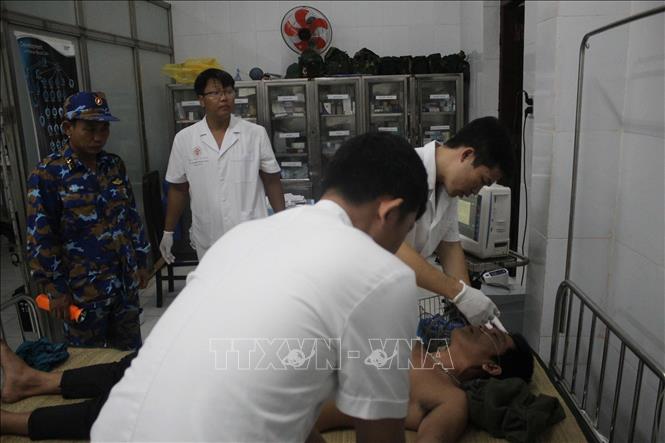Các bác sĩ đảo Song Tử Tây thăm khám cho ngư dân bị giảm áp. Ảnh: TTXVN phát