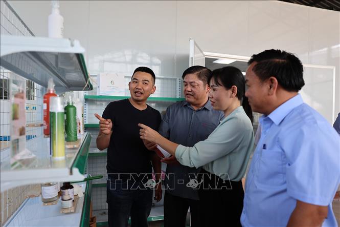 Đại diện Chi cục Phát triển nông thôn TP. Hồ Chí Minh và UBND xã Nghĩa Thành tham quan sản phẩm của Hợp tác xã Đá Bạc xanh. Ảnh: Hoàng Nhị - TTXVN.