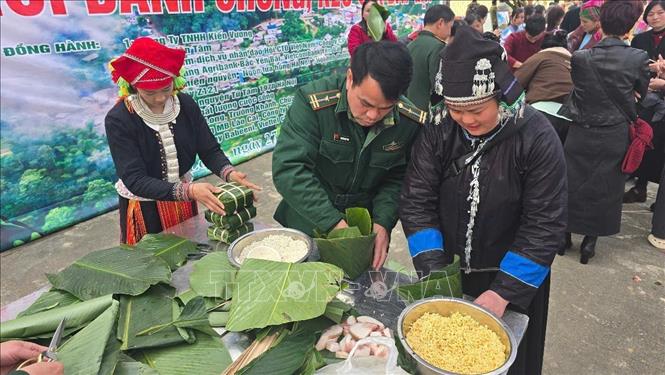 Quân, dân Pha Long tham gia thi gói bánh chưng Tết. Ảnh: Hương Thu - TTXVN               