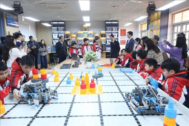 Các đại biểu tham quan không gian phòng học, trải nghiệm các thiết bị công nghệ hiện đại và mô hình sản phẩm STEM của học sinh tại phòng thực hành STEM của Trường THCS Vĩnh Trại. Ảnh: Anh Tuấn – TTXVN