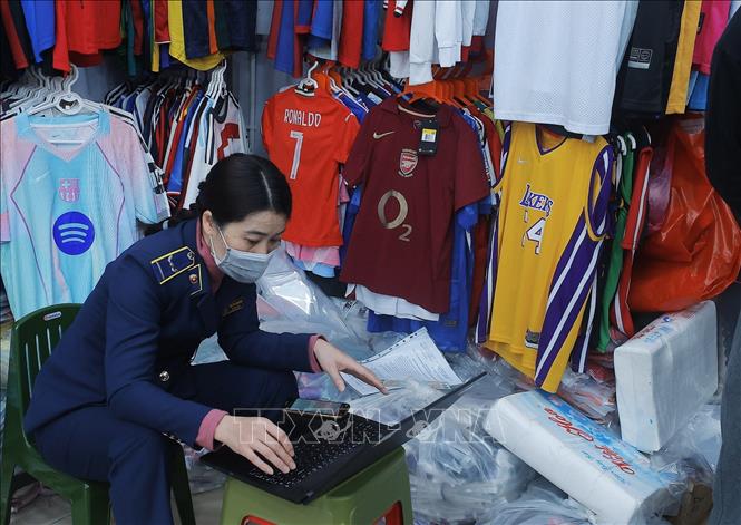 Lực lượng chức năng lập biên bản tại cửa hàng 83 phố Hàng Điếu. Ảnh: Trần Việt - TTXVN