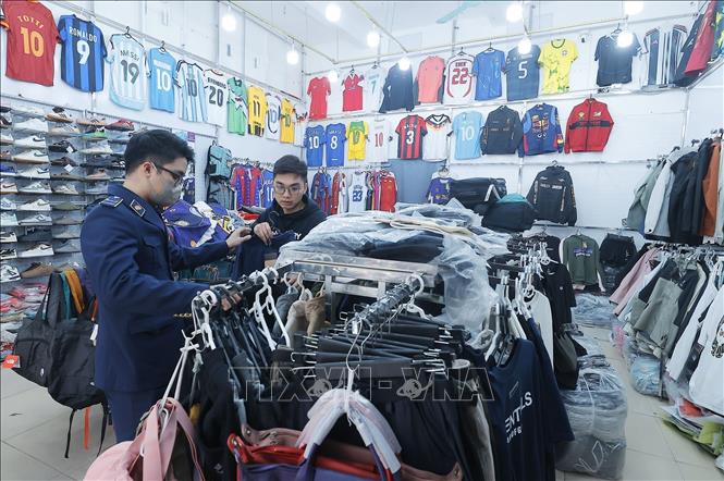 Lực lượng chức năng kiểm tra tại cửa hàng 83 phố Hàng Điếu. Ảnh: Trần Việt - TTXVN