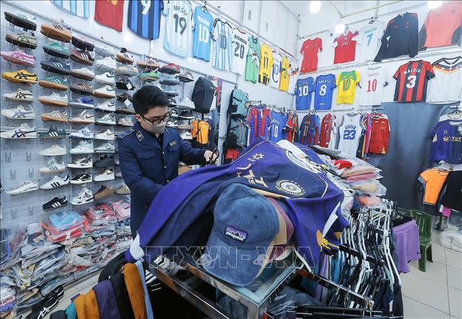 Lực lượng chức năng kiểm tra tại cửa hàng 83 phố Hàng Điếu. Ảnh: Trần Việt - TTXVN