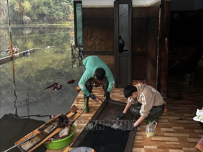 Người dân tiến hành dọn dẹp, khắc phục hậu quả sau ngập lụt. Ảnh: TTXVN phát