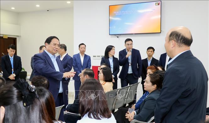 Thủ tướng Phạm Minh Chính thăm hỏi, động viên cán bộ, công chức, viên chức đang làm việc tại Trung tâm. Ảnh: Văn Đức - TTXVN