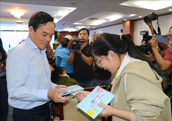 Ông Trần Lưu Quang, Ủy viên Bộ Chính trị, Bí thư Thành ủy Thành phố Hồ Chí Minh thăm hỏi, động viên và tặng quà cho đoàn viên công nhân lao động có hoàn cảnh khó khăn tại buổi họp mặt. Ảnh: Thanh Vũ-TTXVN
