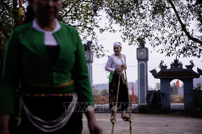 Trò đi cà kheo là trò chơi dan gian quen thuộc của các Mế Mường trong những ngày hội. Ảnh: Trọng Đạt-TTXVN