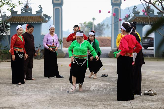 Các mế mường và đàn ông Mường chơi trò chơi đáng mảng của người Mường. Ảnh: Trọng Đạt-TTXVN