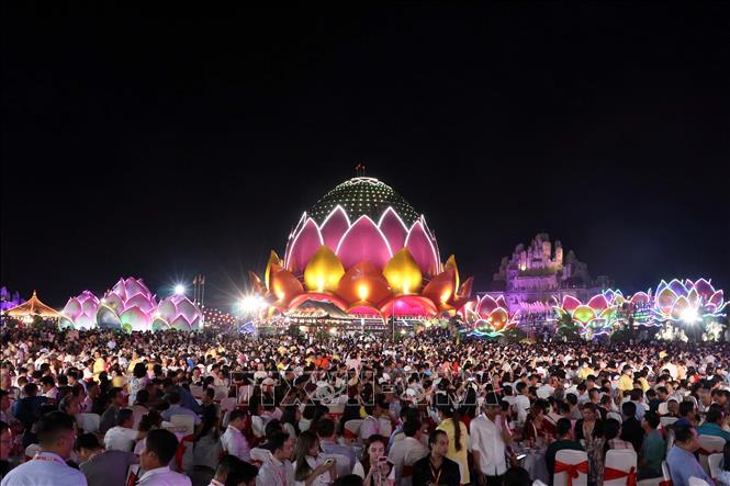 Đông đảo quan khách và người dân địa phương tham dự tiệc chiêu đãi trong không gian rực rỡ ánh đèn nghệ thuật của Liên Hoa Bảo Tháp về đêm. Ảnh: Trung Kiên - TTXVN