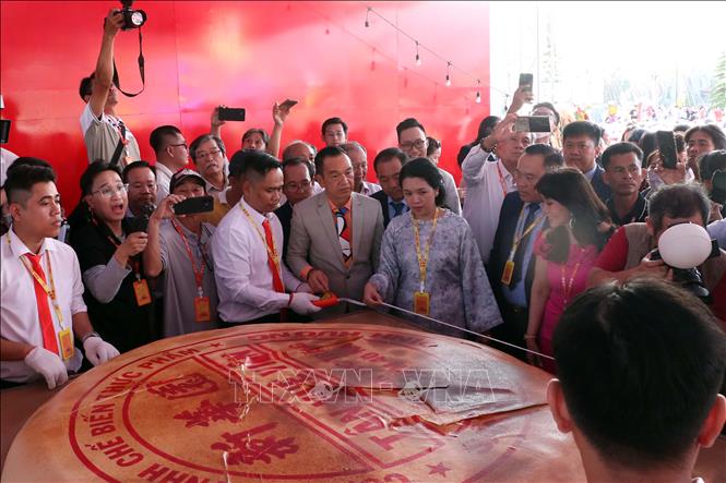 Các đại biểu và thành viên Hội đồng Xác lập Tổ chức Kỷ lục Việt Nam thực hiện đo đạc, kiểm tra thông số kỹ thuật của chiếc bánh Pía khổng lồ trong khuôn khổ sự kiện. Ảnh: Trung Kiên - TTXVN