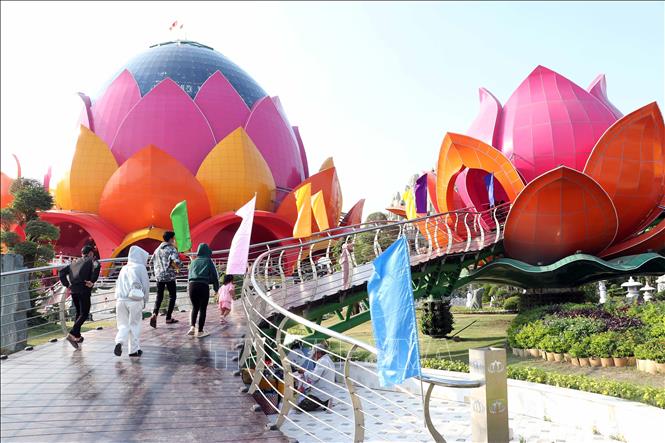 Khách tham quan di chuyển trên cầu dẫn vào các đài sen vệ tinh trong quần thể kiến trúc Liên Hoa Bảo Tháp. Ảnh: Trung Kiên - TTXVN