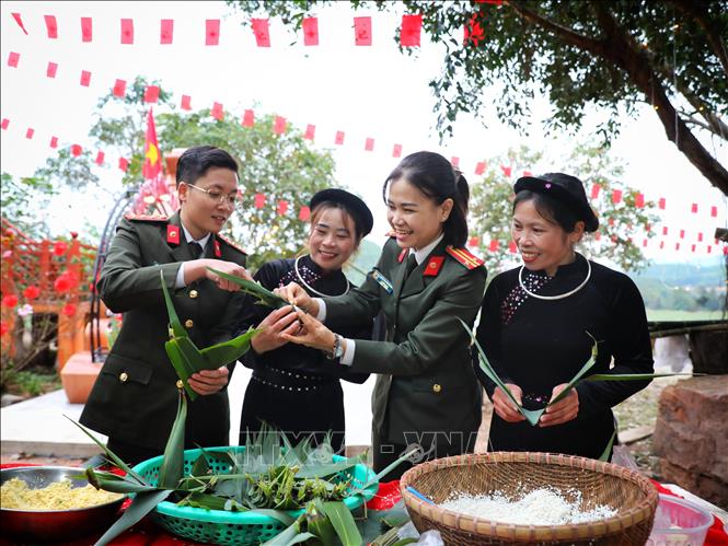 Hội Phụ nữ Công an tỉnh Bắc Ninh cùng người dân xã miền núi An Lạc gói bánh trưng, giã bánh dày trong chương trình “Tết ấm”. Ảnh: Danh Lam - TTXVN