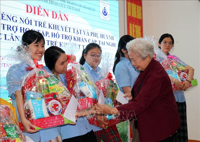 Bà Lương Thị Thuận, Chủ tịch Hội Bảo trợ trẻ em Thành phố Hồ Chí Minh trao tặng quà Tết cho trẻ khuyết tật tại diễn đàn. Ảnh: Thanh Vũ-TTXVN
