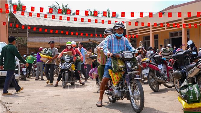 Người khuyết tật, người yếu thế trên địa bàn xã Mỹ Quý chở quà Tết gồm gạo, bánh mứt và nhu yếu phẩm về nhà. Ảnh: Minh Phú – TTXVN