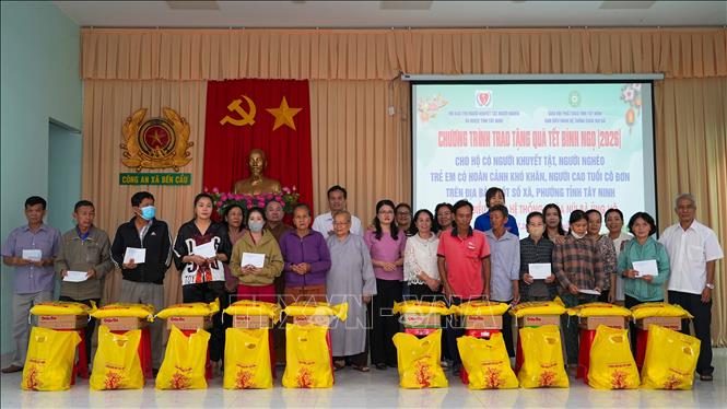 Lãnh đạo tỉnh Tây Ninh, Hội Bảo trợ người khuyết tật, người nghèo và bảo vệ quyền trẻ em tỉnh Tây Ninh cùng đại diện Ban Điều hành hệ thống chùa Núi Bà Tây Ninh trao quà Tết cho người dân có hoàn cảnh khó khăn tại xã Bến Cầu, tỉnh Tây Ninh. Ảnh: Minh Phú – TTXVN 