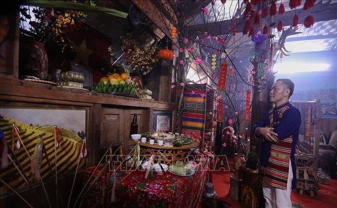 Thầy cúng làm lễ dâng lên tổ tiên mâm cỗ cúng trong đêm giao thừa. Ảnh: Trọng Đạt-TTXVN