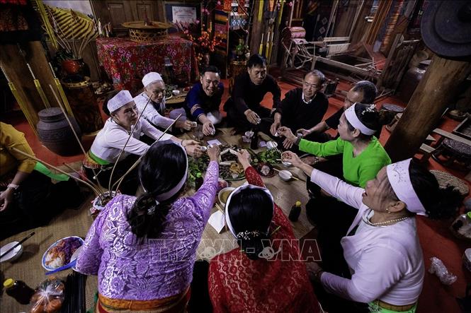 Phường bùa sau khi sắc bùa chúc tết sẽ được chủ nhà mời nâng chén chung vui cùng gia đình trong những ngày xuân. Ảnh: Trọng Đạt-TTXVN