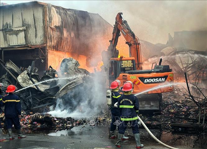 Lực lượng chức năng đang nỗ lực khống chế đám cháy. Ảnh: Danh Lam -TTXVN 