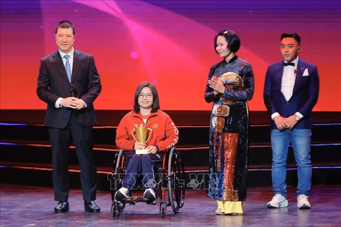Ban tổ chức trao giải thưởng VĐV người khuyết tật xuất sắc của năm cho kình ngư Vi Thị Hằng môn bơi. Ảnh: Minh Quyết - TTXVN