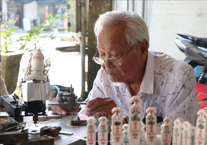 Làm xăm hường đòi hỏi đôi tay khéo léo cũng như phải am hiểu luật chơi và ý nghĩa văn hóa ẩn sau từng quân xăm. Ảnh: Mai Trang - TTXVN 