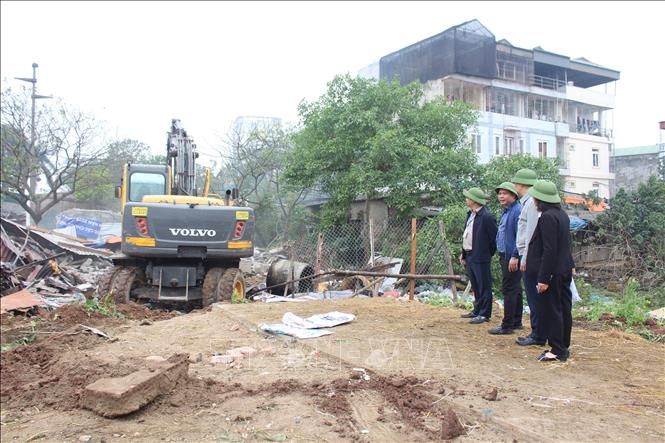 Lãnh đạo UBND phường Hoàng Mai chỉ đạo tại hiện trường đảm bảo an toàn công tác cưỡng chế. Ảnh: Nguyễn Thắng - TTXVN
