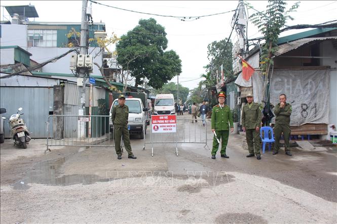Lực lượng chức năng dựng rào chắn, bảo vệ đảm bảo an toàn khu vực cưỡng chế. Ảnh: Nguyễn Thắng - TTXVN