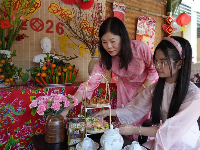 Tại mỗi khối lớp, học sinh được tham gia những chủ đề trải nghiệm riêng, cùng cha mẹ gói bánh chưng, trang trí gian hàng, tìm hiểu phong tục Tết cổ truyền. Ảnh: Bích Huệ - TTXVN