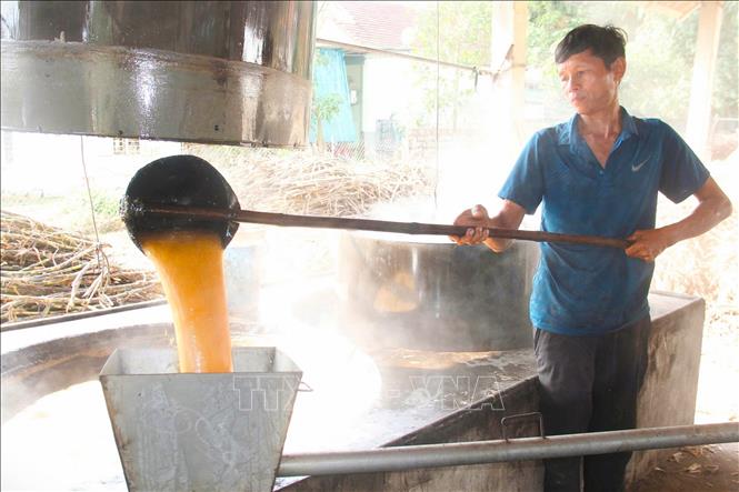 Một mẻ mật mía trải qua khoảng thời gian nấu từ 3 đến 4 giờ. Trong đó, hơn nửa thời gian mật mía mới sủi tăm và sôi. Khi mật mía sôi, người nấu phải luôn tay vớt bọt và tạp chất nổi lên trong các chảo nấu để đảm bảo mật mía có chất lượng, màu sắc đẹp. Ảnh: Xuân Tiến - TTXVN 