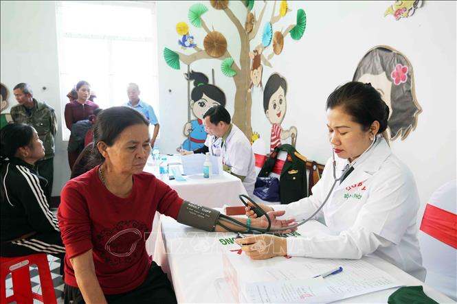 Bác sĩ kiểm tra huyết áp cho người dân vùng biên giới. Ảnh: Hữu Quyết - TTXVN