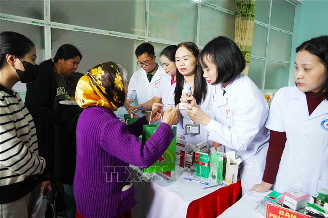 Lực lượng quân y hướng dân người dân sử dụng thuốc. Ảnh: Hữu Quyết - TTXVN