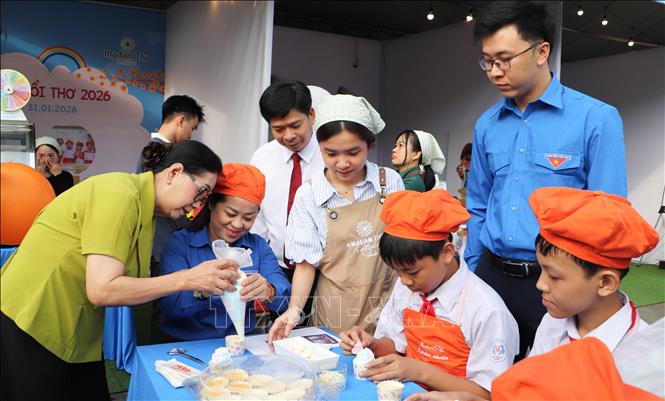 Các em thiếu nhi trải nghiệm làm bánh tại chương trình. Ảnh: Hồng Thái - TTXVN