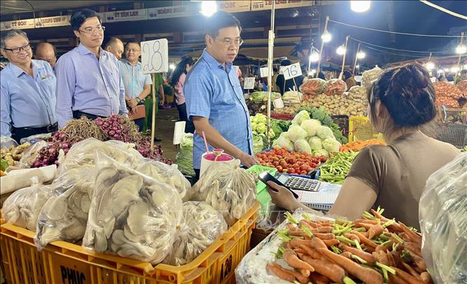 Phó Chủ tịch UBND TP. Hồ Chí Minh trao đổi về nguồn cung, giá cả với thương nhân tại chợ đầu mối nông sản thực phẩm Hóc Môn. Ảnh: Hương Giang – TTXVN