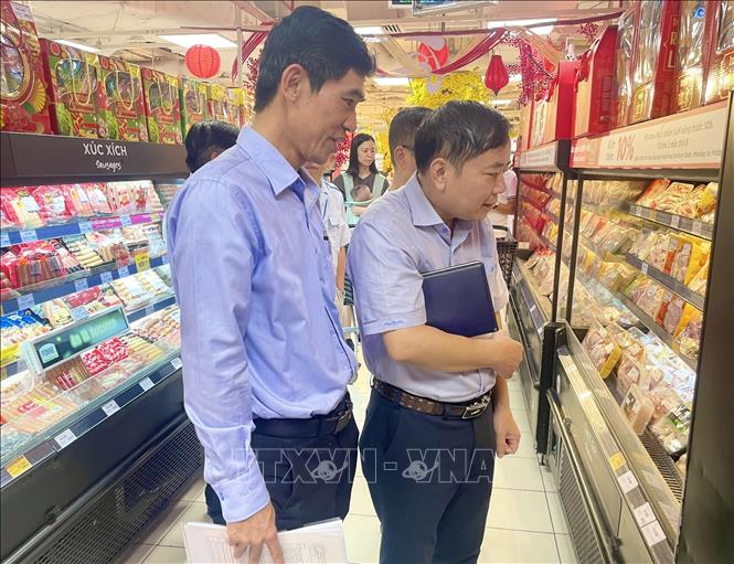 Đại diện Sở Công Thương và Sở An toàn thực phẩm TP. Hồ Chí Minh khảo sát nguồn hàng Tết cung tại siêu thị. Ảnh: Hương Giang – TTXVN