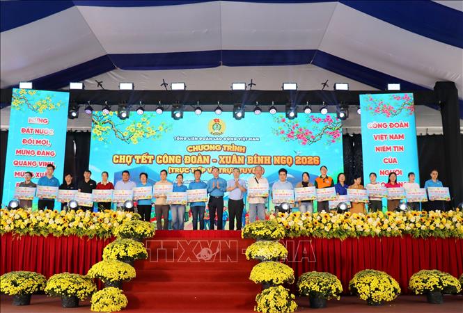 Ông Nguyễn Đình Khang, Chủ tịch Tổng Liên đoàn Lao động Việt Nam và ông Nguyễn Phước Lộc, Phó Bình thư Thành ủy Thành phố Hồ Chí Minh trao tặng vé máy bay cho công nhân lao động về quê đón Tết. Ảnh: Thanh Vũ-TTXVN